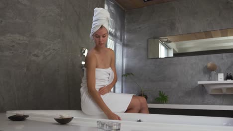 Caucasian-woman-preparing-bath-in-hotel