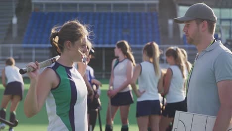 Hockey-coach-explaining-game-plan-to-female-player-in-the-field