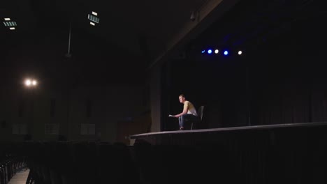 Caucasian-teenage-boy-in-the-high-school-auditorium-preparing-for-a-performance