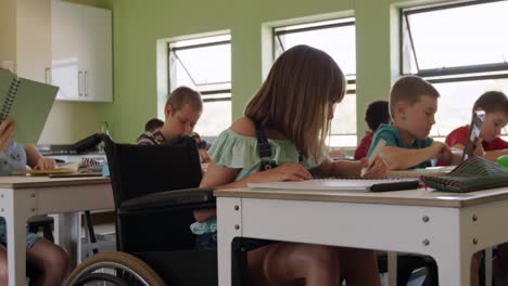 Körperlich-Behindertes-Mädchen,-Das-In-Der-Klasse-In-Ihr-Notizbuch-Zeichnet