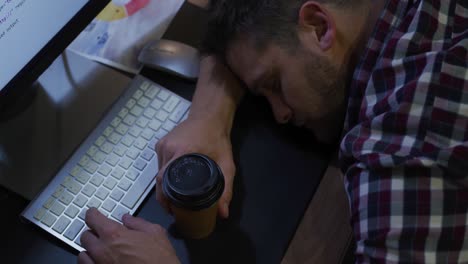 Businessman-sleeping-in-a-modern-office-by-night