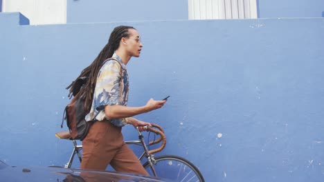 Mixed-race-man-walking-with-a-bike