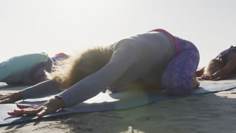 Mujeres-Atléticas-Realizando-Yoga-En-La-Playa