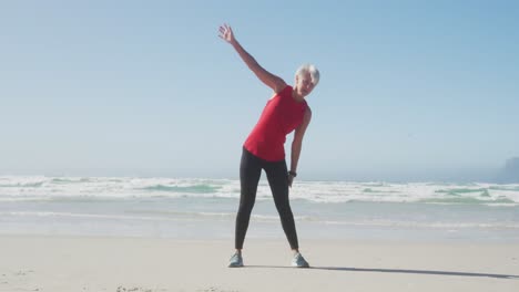 Senior-woman-stretching-in-the-beach