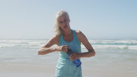 Ältere-Frau-Trinkt-Wasser-Am-Strand