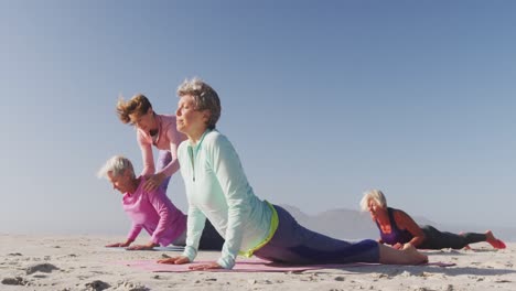 Yoga-teacher-teaching-yoga-to-senior-women-at-the-beach