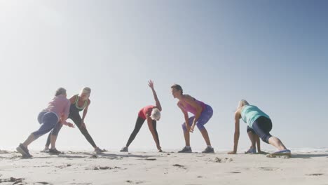 Senior-women-stretching-in-the-beach