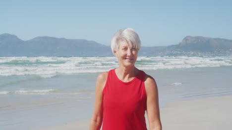 Senior-woman-smiling-and-looking-at-camera-on-the-beach