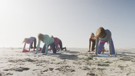 Athletic-women-performing-yoga-in-the-beach