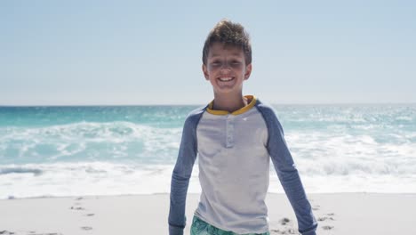Boy-standing-on-the-beach-and-looking-at-camera