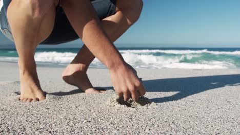 Man-crouching-on-the-beach