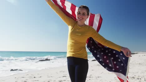 Mujer-Sosteniendo-La-Bandera-Americana-En-La-Playa