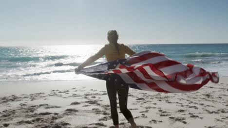 Frau-Hält-Amerikanische-Flagge-Am-Strand