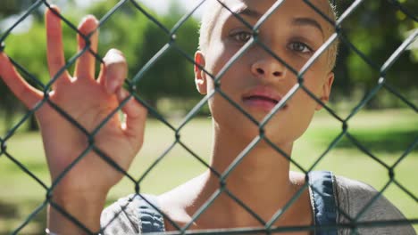 Mixed-race-woman-looking-through-a-fence-