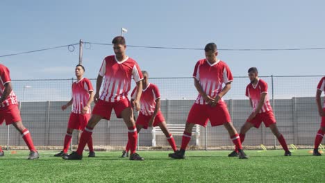 Jugadores-De-Fútbol-Estirándose-En-El-Campo