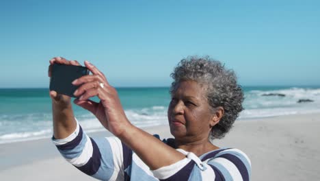 Senior-woman-taking-photos-at-the-beach