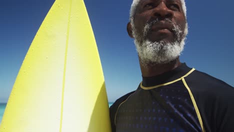 Senior-man-with-a-surfboard-at-the-beach