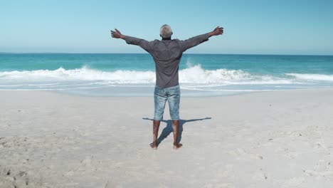 Senior-man-raising-his-arms-at-the-beach