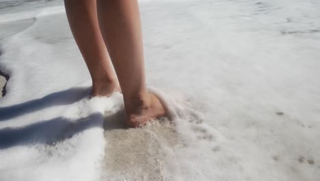 Young-girl-putting-her-feet-on-the-water