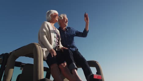 Älteres-Paar-Fotografiert-Auf-Einem-Auto-Sitzend