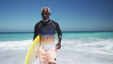 Senior-man-running-with-a-surfboard