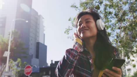 Mixed-race-woman-listening-music-on-the-street