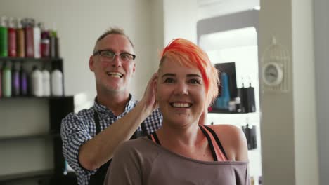 Front-view-hairdresser-showing-at-woman-her-hair