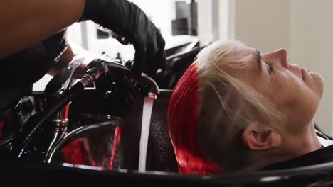 Side-view-woman-having-her-hair-washed-by-a-hairdresser