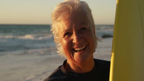 Ältere-Frau-Mit-Einem-Surfbrett-Lächelnd