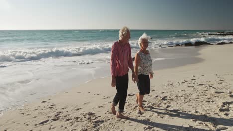Seniorenpaar-Geht-Gemeinsam-Am-Strand-Spazieren