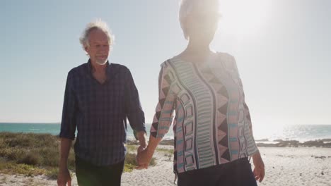 Senior-couple-walking-together-at-the-beach