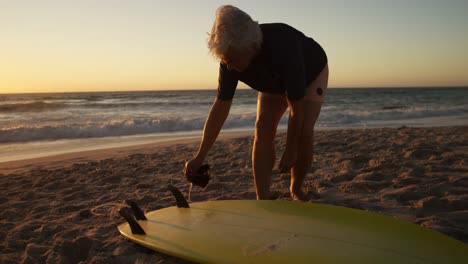 Senior-woman-preparing-to-surf-at-the-beach