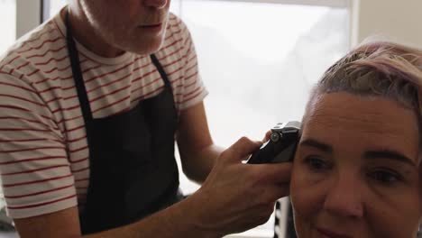 Front-view-woman-having-her-hair-cut-by-a-hairdresser