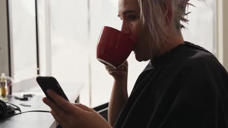 Seitenansicht-Einer-Frau,-Die-Ihr-Telefon-Benutzt-Und-Kaffee-Trinkt