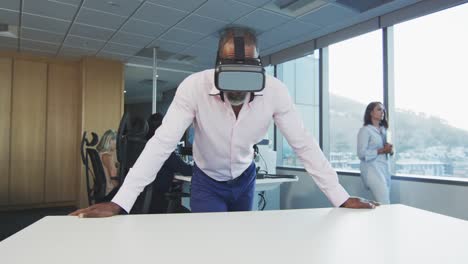 African-American-businessman-wearing-VR-headset-in-modern-office