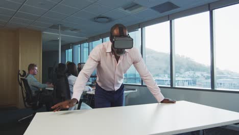 African-American-businessman-wearing-VR-headset-in-modern-office