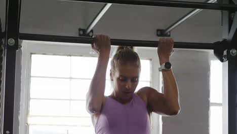 Front-view-athletic-Caucasian-woman-doing-chin-ups