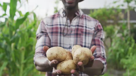 Afroamerikanischer-Mann-Zeigt-Kartoffeln-In-Die-Kamera