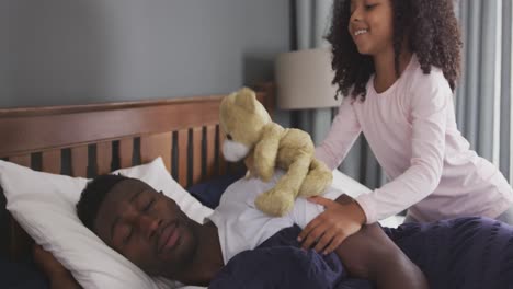 African-american-girl-waking-up-her-father