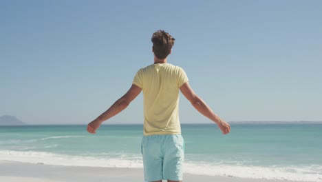 Caucasian-man-enjoying-the-fresh-air-at-beach-