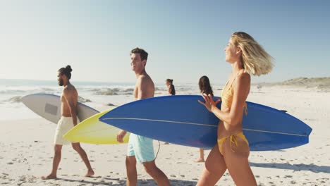 Side-view-of-mixed-race-friends-ready-to-go-surf-