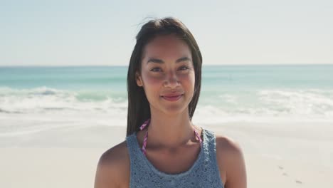 Mixed-race-woman--laughing-at-beach-and-looking-at-the-camera