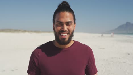 Mixed-race-man-smiling-at-beach-and-looking-at-camera-