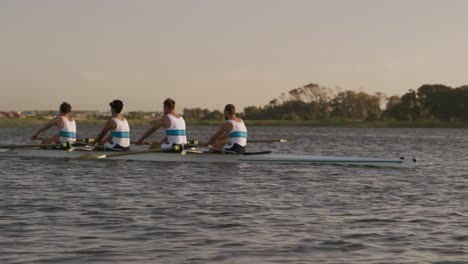 Side-view-of-male-rower-team-rowing-on-the-lake