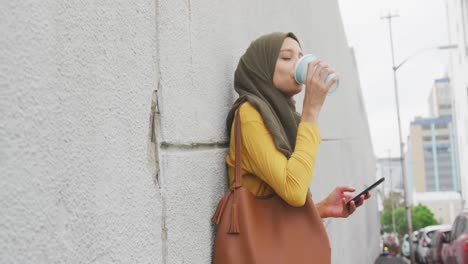 Frau-Mit-Hijab-Trinkt-Auf-Der-Straße-Und-Trinkt-Einen-Kaffee-Zum-Mitnehmen