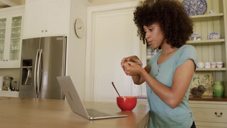 Mixed-race-woman-eating-breakfast-in-their-kitchen