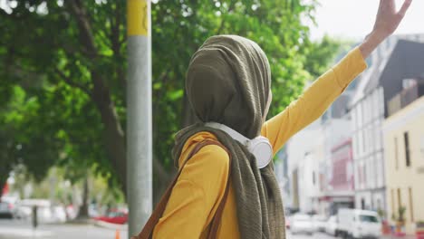 Frau-Trägt-Hijab-Und-Kabellose-Kopfhörer-Auf-Der-Suche-Nach-Einem-Bus