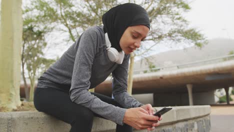 Frau-In-Sportkleidung-Trägt-Hijab-Und-Benutzt-Draußen-Ihr-Telefon