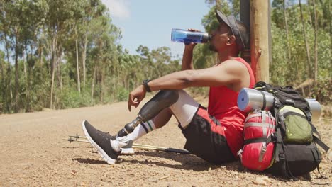 Sporty-mixed-race-man-with-prosthetic-leg-drinking-water