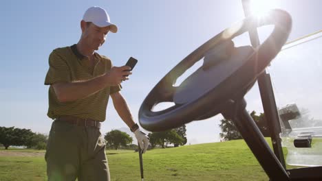 Kaukasischer-Männlicher-Golfer,-Der-Sein-Smartphone-Auf-Einem-Golfplatz-Benutzt